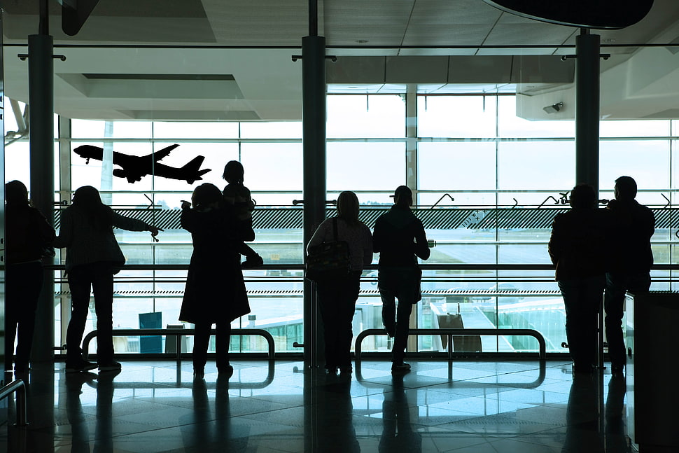 silhouette of group of people standing inside an airport HD wallpaper
